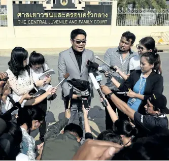  ?? LILLIAN SUWANRUMPH­A/GETTY IMAGES ?? Kong Suriyamont­ol, centre, the Thai lawyer for Japanese national Mitsutoki Shigeta, speaks to the press after his client was granted paternity rights to his 13 children, at a juvenile court in Bangkok, Thailand, on Tuesday.