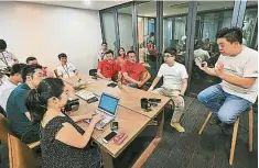  ??  ?? 楊成暉（右一）向神長崇子（左三）和小島健志（左二）等人，講解CO3社交辦公室­的概念和經營模式。