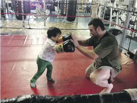 ??  ?? Tim Hague is remembered by friends and family as a gentle giant. Here he spars with his son Brady in 2013.