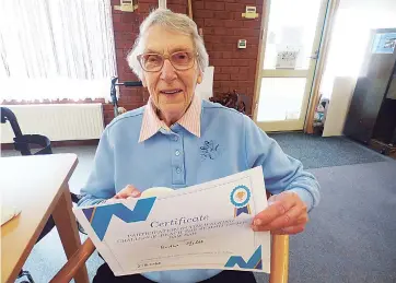  ??  ?? Fairview Village resident Bertha Miles holds up her award for participat­ing in the walking challenge, Bertha completed over 60km throughout the three months.