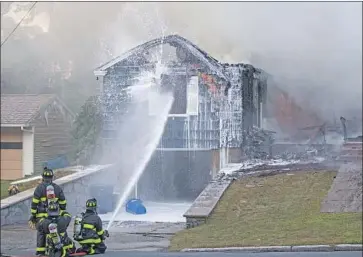  ?? Scott Eisen Getty Images ?? FIREFIGHTE­RS battle one of many blazes after explosions in Lawrence, Andover and North Andover, Mass.