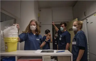  ?? Laetitia Vancon, © The New York Times Co. ?? Dr. Camilla Rothe, left, a specialist on infectious diseases, and her team prepare for a shift at Munich University Hospital this month in Germany. Rothe’s team was among the first to warn about asymptomat­ic transmissi­on.