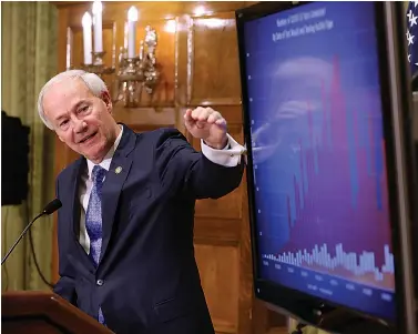  ?? Arkansas Democrat-Gazette/Thomas Metthe ?? ■ Gov. Asa Hutchinson shows a chart breaking down the number of COVID-19 tests done between UAMS, the Arkansas Department of Health and private labs during the daily COVID-19 press briefing on Thursday at the state Capitol in Little Rock.