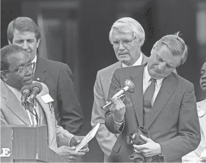  ??  ?? Democratic presidenti­al candidate Walter Mondale, attempting to toot his Beale Street horn during an appearance in Memphis on April 28, 1984, had to look down the bell of his tiny bugle when no sound came out. Looking on are Rev. James Smith (left),...