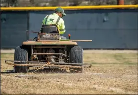  ??  ?? A landscape techncian works to restore outfield grass at the William S. Hart Baseball and Softball Complex in Valencia on Tuesday. The field was damaged after a motorist crashed through a fence and perfomed stunts on the turf early Sunday morning....