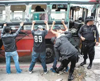  ??  ?? La policía revisa a los pasajeros, después de detener un autobús en el área de El Milagro, del municipio de Mixco, en las afueras de la ciudad de Guatemala.