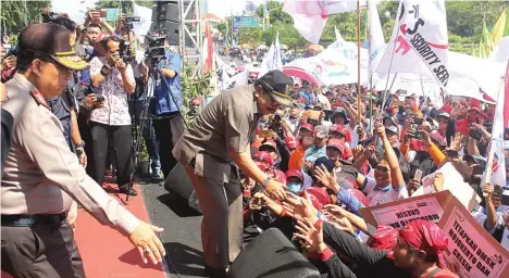  ?? BAYU/JAWA POS ?? AKRAB: Gubernur Jawa Timur Soekarwo menyalami para buruh yang berunjuk rasa di kantor gubernur di Jalan Pahlawan, Surabaya, kemarin.