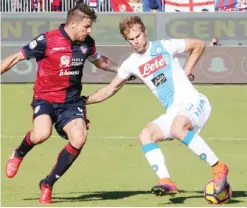  ?? — AFP ?? CAGLIARI: Napoli’s Croatian defender Ivan Strinic (R) fights for the ball with Cagliari’s Italian midfielder Daniele Dessena during the Italian Serie A football match Cagliari Calcio vs SSC Napoli at the Sant’Elia Stadium in Cagliari yesterday.