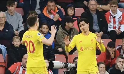  ?? Picture: AFP ?? ON SONG. Liverpool’s Takumi Minamino (right) celebrates with team-mate Diogo Jota after scoring a goal during their English Premier League match against Southampto­n at St Mary’s Stadium on Tuesday night.