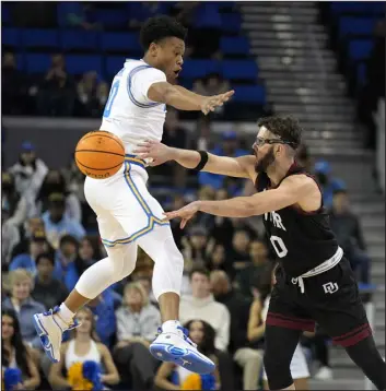  ?? MARK J. TERRILL — THE ASSOCIATED PRESS ?? Denver guard Marko Lukic, right, passes as UCLA guard Jaylen Clark defends during the first half Saturday in Los Angeles.