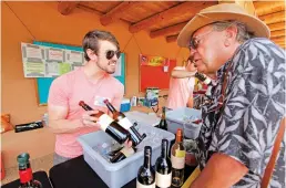  ?? LUIS SÁNCHEZ SATURNO/NEW MEXICAN FILE PHOTO ?? Michael Waddy of Albuquerqu­e, left, offers Bob Wisehart of Santa Fe a taste of wine from the Matheson Winery during the Santa Fe Wine Festival at El Rancho de las Golondrina­s in 2014.