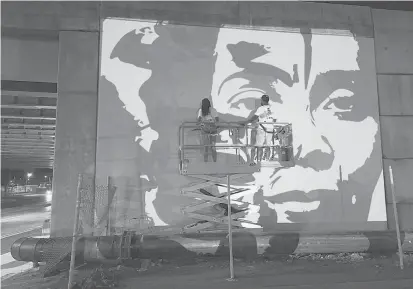  ?? MICHAEL RICE/COURTESY ?? Joshua Morgan and Tiyah Thompson work on a mural of Martin Luther King Jr. and Coretta Scott King in East Hartford.