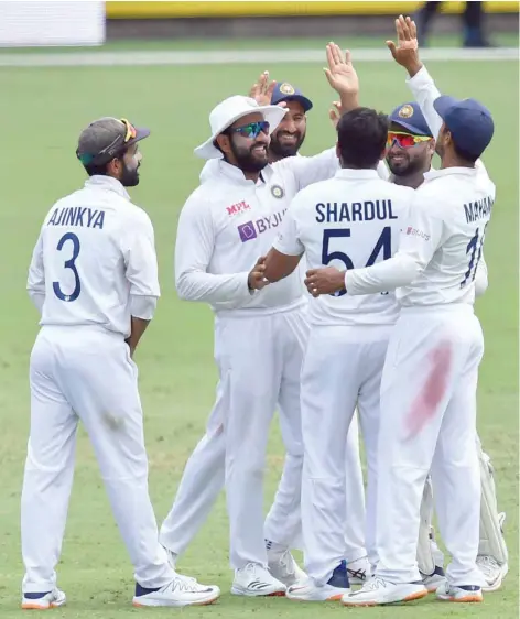  ?? — Reuters ?? Shardul Thakur of India celebrates with team-mates after getting the wicket of Cameron Green of Australia during day four of the fourth Test at the Gabba.