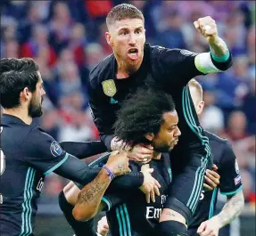  ?? REUTERS ?? Marcelo is mobbed by Sergio Ramos (top) and Isco after the Brazilian scored Real Madrid’s opener in its 2-1 Champions League semifinal first-leg victory at Bayern Munich on Wednesday.