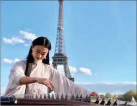  ?? Or Chinese zither, to passersby PROVIDED TO CHINA DAILY ?? Peng Jingxuan, 26, plays the guzheng, in Paris in October 2018.