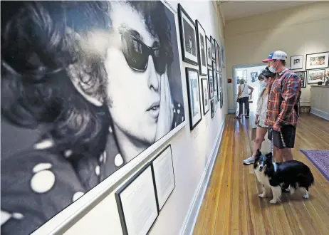  ?? LUIS SÁNCHEZ SATURNO/THE NEW MEXICAN ?? Bobby Babcock, of Tulsa, Okla., his wife, Kari Babcock, and their dog Lucy walk through the Museum of the Sixties on Monday. The temporary-hoping-to-become-permanent exhibition of the cultural, political and historical events of the decade are on display on San Francisco Street.