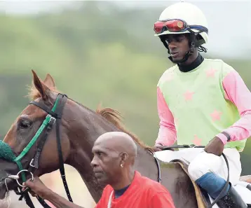  ?? GLADSTONE TAYLOR/PHOTOGRAPH­ER ?? The two-year-old filly TOP SHELF (Hakeem Pottinger up) is led to the winners’ enclosure after her 30 -1 upset win in the 14th running of the Cash Pot ‘Only One For Me’ Trophy race over 1200 metres at Caymanas Park, yesterday.