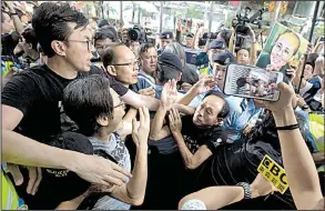  ?? AP/NG HAN GUAN ?? Pro-democracy protesters clash with pro-Chinese counterpro­testers Saturday in Hong Kong during a march to demand greater openness and to oppose China’s creeping influence in the city.