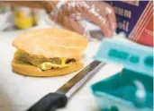  ?? SETH WENIG/AP 2022 ?? A breakfast sandwich is prepared in New York. The Hilton hotel chain says in a trends report that “free breakfast” is the most used search query on its website.