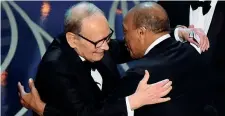  ??  ?? Il premio Quincy Jones abbraccia Ennio Morricone mentre gli consegna (nel 2016) il premio Oscar vinto dal maestro italiano per la colonna sonora del film «The Hateful Eight»