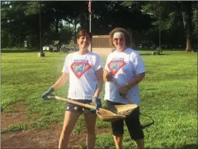  ?? PHOTO COURTESY OF AMY FRANCIS ?? GoFourth Festival volunteers Amy Wolf and Suzy Kennedy shovel dried river mud out of the island area of Memorial Park.