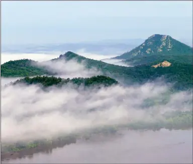  ?? ?? Morning fog begins to lift above Pinnacle Mountain State Park on the banks of the Arkansas River near Little Rock in May 2015. (AP file photo/Danny Johnston)