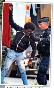  ??  ?? Collared: A migrant is pulled from a vehicle by a policeman