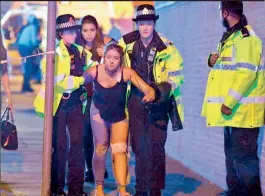  ?? — AP ?? An Injured fan being escorted from the scene of a terrorist attack during a pop concert by US star Ariana Grande in Manchester, northwest England, on Tuesday.