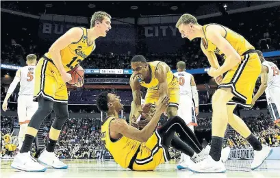  ?? STREETER LECKA/GETTY IMAGES ?? Jourdan Grant (5) and teammate Arkel Lamar (33) of the UMBC Retrievers are pumped after a score against the Virginia Cavaliers.