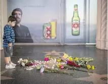  ?? DAVID MCNEW/GETTY IMAGES ?? A boy looks at a tribute set up on the Tom Petty and the Heartbreak­ers star on the Hollywood Walk of Fame. Petty, 66, suffered a massive heart attack and died Monday.