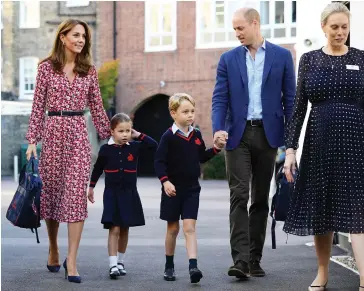  ??  ?? Princess Charlotte of Cambridge, accompanie­d by her father, Prince William, Duke of Cambridge, her mother, Catherine, Duchess of Cambridge and her brother, Prince George of Cambridge, is welcomed by Helen Haslem, head of the lower school, on her arrival for her first day of school at Thomas’s Battersea in London on Thursday.