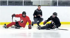  ?? DAVE JOHNSON/ WELLAND TRIBUNE ?? Team Canada sledge hockey players Tyler McGregor, left, and Antoine Lehoux, right, pass by athletic therapist James Sawchuk during a morning session at Vale Health and Wellness Centre in Port Colborne.