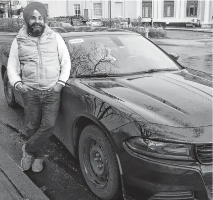  ?? RYAN TAPLIN • THE CHRONICLE HERALD ?? Uber driver Gurmeet Randhawa poses next to his car on Hollis Street on Sunday.