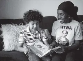  ?? IVY CEBALLO Tampa Bay Times ?? Mason Davis, 6, reads a book for his grandmothe­r, Rosemary McCoy, 63, inside his family’s Jacksonvil­le apartment.