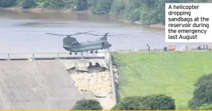  ??  ?? A helicopter dropping sandbags at the reservoir during the emergency last August