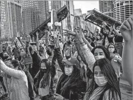  ?? ARMANDO L. SANCHEZ/CHICAGOTRI­BUNE ?? Supporters celebrate Saturday near Trump Internatio­nal Hotel & Tower in Chicago after Joe Biden defeated President Trump to become the 46th president of the United States .