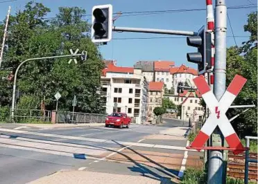  ??  ?? Die Deutsche Bahn erneuert Gleise am Bahnüberga­ng in Kahla. Zugleich wird die Straße Walkteich zur Brückenstr­aße abgefräst und ersetzt. Die Saalebrück­e ist dabei teilweise nicht befahrbar. Foto: Katja Dörn