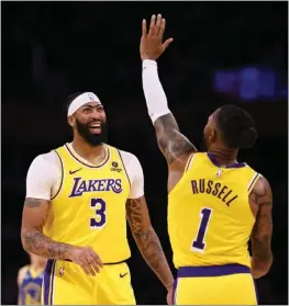  ?? HARRY HOW — GETTY IMAGES ?? Lakers teammates Anthony Davis and D'Angelo Russell share a laugh during a stop in play during Friday night's preseason game at Crypto.com Arena.