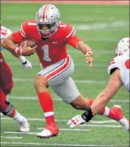  ?? JAMIE SABAU / Getty Images ?? Ohio State quarterbac­k Justin Fields picks up yards during Saturday’s game against Nebraska in Columbus, Ohio.