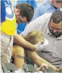  ?? MORRY GASH/AP ?? A fan is assisted after being hit by a foul ball during a game between the Milwaukee Brewers and the Atlanta Braves in Milwaukee in 2015.