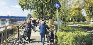  ?? THOMAS HUSMANN ?? Eindeutige­s Schild: Auf der Behelfsbrü­cke müssen Räder geschoben werden.BILD: