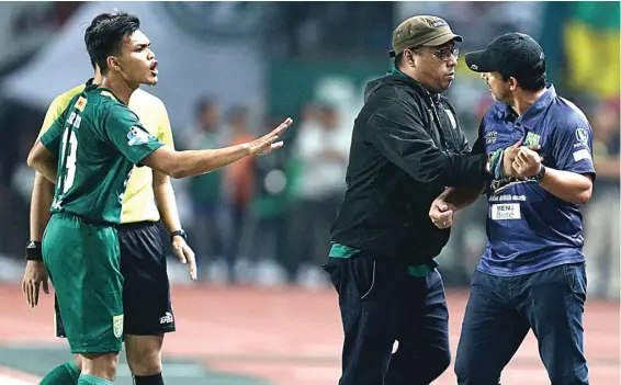  ?? ANGGER BONDAN/JAWA POS ?? KEBINGUNGA­N: Bek Persebaya Rachmat Irianto dan Manajer Chairul Basalamah menenangka­n pelatih Angel Alfredo Vera ketika menghadapi Persib di Stadion Gelora Bung Tomo, Surabaya, tadi malam.