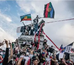  ?? TOMAS MUNITA The New York Times ?? Protesters in Santiago wave Mapuche flags on Oct. 25, 2019. Chile’s Mapuche have long demanded official recognitio­n of their culture and of their claims to ancestral lands. A referendum over a new constituti­on provides them a chance to be included.