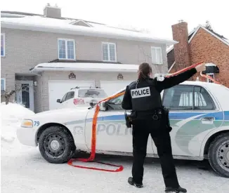  ?? MIKE CARROCCETT­O /OTTAWA CITIZEN ?? A police officer is seen outside the home of Patrick Brazeau on Feb. 7. According to search warrant records, the alleged victim said the senator pushed her in the stairway, breaking the railing she was holding onto.