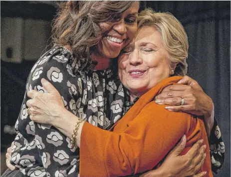 ??  ?? First lady Michelle Obama and Hillary Clinton hug at Wake Forest University in Winston- Salem, North Carolina, Thursday. | ANDREW HARNIK/ AP