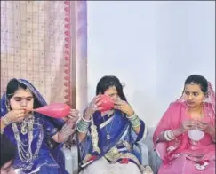  ??  ?? ▪ Shobha (centre) inflates a balloon ahead of the farewell party for students of Class 12. All three are dressed in traditiona­l Rajasthani outfits for a dance competitio­n that is part of the celebratio­n. Sponsorshi­p schemes help pay for further...