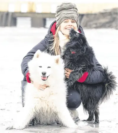  ?? PHOTO: ANDREW DOWNES ?? Calm before the storm: Musician Sharon Shannon takes her dogs Misty and Gnasher for a walk on the beach at Salthill in Galway city ahead of Storm Erik.