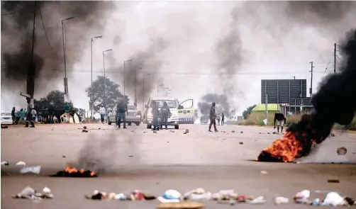  ?? African News Agency (ANA) | THOBILE MATHONSI ?? POLICE keep the peace as residents shut down the streets of Soshanguve, outside Pretoria, with burning tyres and rocks while demanding service delivery last month.