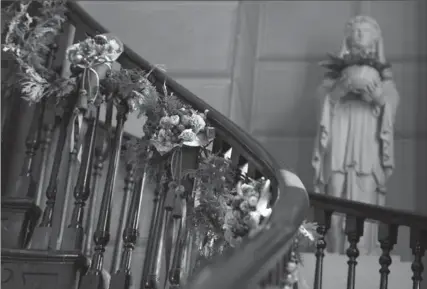  ??  ?? Left: Small clusters of ornaments with faux fruits and dried flowers adorn the grand staircase.