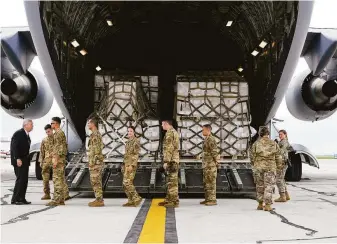  ?? Michael Conroy / Associated Press ?? Agricultur­e Secretary Tom Vilsack (left) greets crew members of a U.S. Air Force cargo plane that landed with a load of baby formula from Europe at Indianapol­is Internatio­nal Airport.